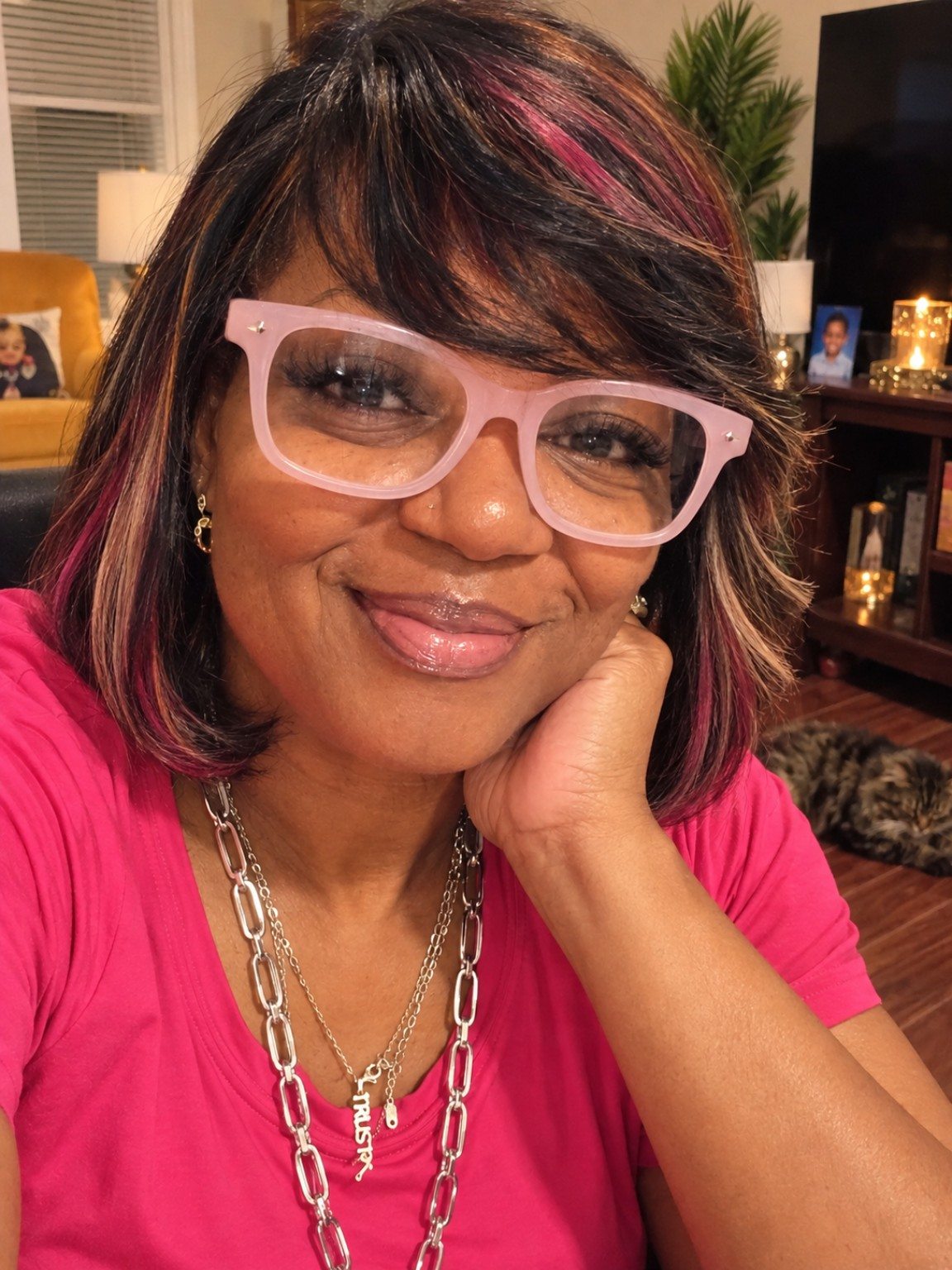 A smiling woman wearing glasses and a pink top